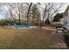 Spacious backyard with an in-ground pool, a black metal fence, and mature trees adding privacy at 523 Fence Post Ln, Matthews, NC 28105