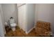 Bathroom with a toilet, basket, and a patterned curtain over the shower at 523 Fence Post Ln, Matthews, NC 28105