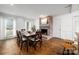 Dining room featuring a brick fireplace, large windows, and wood floors at 523 Fence Post Ln, Matthews, NC 28105