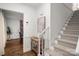 Hallway featuring hardwood floors and a staircase with patterned carpet, adjacent to the dining room at 523 Fence Post Ln, Matthews, NC 28105