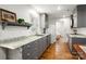 Bright kitchen featuring gray cabinetry, granite counters, stainless steel appliances, and hardwood floors at 523 Fence Post Ln, Matthews, NC 28105