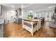 Open concept kitchen with a kitchen island that flows into a dining area with exposed brick fireplace at 523 Fence Post Ln, Matthews, NC 28105