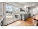 Bright kitchen with white walls, gray cabinetry, hardwood flooring, and access to the backyard at 523 Fence Post Ln, Matthews, NC 28105