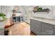 Bright kitchen featuring gray cabinetry, granite counters, hardwood floors, and natural light at 523 Fence Post Ln, Matthews, NC 28105