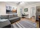 Living room featuring a gray sectional sofa, desk, and a cityscape painting at 523 Fence Post Ln, Matthews, NC 28105