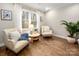 Cozy sitting room with bright natural light, comfortable armchairs, and hardwood flooring at 523 Fence Post Ln, Matthews, NC 28105