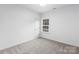 Simple bedroom with neutral walls, carpeted floor, and a window at 6325 Rockwell W Blvd, Charlotte, NC 28269