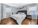 Spacious bedroom with hardwood floors, gray walls, and a tufted headboard at 6737 Lancer Dr, Charlotte, NC 28226