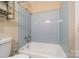 Clean bathroom with light blue tiled walls and bathtub at 6816 Idlewild Rd, Charlotte, NC 28212