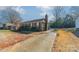 Brick ranch house with driveway and mature trees at 6816 Idlewild Rd, Charlotte, NC 28212