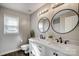 Modern bathroom with double vanity and round mirrors at 9236 Silver Pine Dr, Charlotte, NC 28277