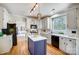 Modern kitchen with white cabinets, center island, and stainless steel appliances at 9236 Silver Pine Dr, Charlotte, NC 28277