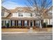 Two-story townhome with brick and siding exterior, welcoming front porch, and landscaping at 10122 Oxford Landing Ln, Charlotte, NC 28270