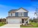 Two-story home with gray and blue siding, two-car garage, and landscaping at 117 Mountain Bridge Way, Statesville, NC 28625