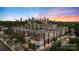 Modern apartment complex showcasing red brick and beige exterior with skyline views at sunset at 1315 East Blvd # 203, Charlotte, NC 28203
