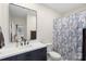 Modern bathroom with dark vanity, white countertop, and patterned shower curtain at 1315 East Blvd # 203, Charlotte, NC 28203