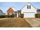 Brick and white exterior house with a two-car garage and well-manicured lawn at 16220 Circlegreen Dr, Charlotte, NC 28273