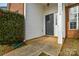 Black front door with a small porch and sidelight window at 16220 Circlegreen Dr, Charlotte, NC 28273