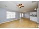 Living room with hardwood floors, ceiling fan, and kitchen view at 16220 Circlegreen Dr, Charlotte, NC 28273