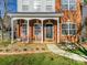 Inviting front porch with rocking chairs, brick columns, and landscaping at 2003 Galty Ln, Charlotte, NC 28270