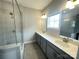 Bathroom featuring double sinks, gray cabinets, and a glass-enclosed shower at 266 Gilead Rd, Huntersville, NC 28078