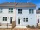 Back exterior of a light blue, two-story townhome with white trim and a small patio at 266 Gilead Rd, Huntersville, NC 28078