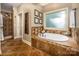 Spa-like bathroom with soaking tub, tile flooring, and large window at 3196 Stonemill Path, Sherrills Ford, NC 28673