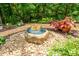 Stone fire pit with blue glass and landscaping at 3196 Stonemill Path, Sherrills Ford, NC 28673