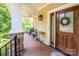 Inviting front porch with wooden door and wreath at 3196 Stonemill Path, Sherrills Ford, NC 28673