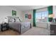 Bright bedroom with gray bed frame, green curtains, and window view at 3917 Coleman Dr, Charlotte, NC 28215