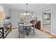 Bright dining room with grey table and chairs, piano, and view into kitchen at 4419 Halstead Dr, Charlotte, NC 28209