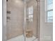 Stand up shower with tile surround and built-in shelving at 450 Caleb St, Monroe, NC 28110