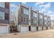 Modern townhome exterior with a brick and gray facade plus rooftop deck and attached garages at 5048 York Park Ln, Charlotte, NC 28217