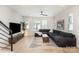 Bright living room with a dark grey sectional, light wood flooring, and a stylish area rug at 5048 York Park Ln, Charlotte, NC 28217