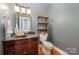 Stylish bathroom with a vessel sink, floating shelves, and dark wood vanity at 6057 Erie View Ct, Denver, NC 28037