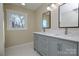 Bathroom featuring a double vanity with gray cabinets, modern fixtures, and a window view at 6615 Love Mill Rd, Monroe, NC 28110