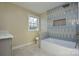 Modern bathroom with blue and beige tile, a bathtub and a toilet at 6615 Love Mill Rd, Monroe, NC 28110