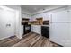 Galley-style kitchen with white cabinets and black appliances at 7151 Stonington Ln, Charlotte, NC 28227