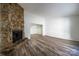 Spacious living room featuring a stone fireplace and laminate wood floors at 7151 Stonington Ln, Charlotte, NC 28227