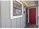 Condo entrance with red door, gray siding, and a window at 7608 Woods Ln # 12, Cornelius, NC 28031