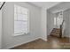 Bright entryway with hardwood floors, stairs, and a large clock at 7840 Denmark Rd, Charlotte, NC 28273