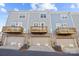 Rear view of townhouses showcasing private garages and wooden decks at 7840 Denmark Rd, Charlotte, NC 28273