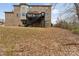 A brick two-story house boasts a dark wooden deck and stairs leading to a spacious backyard covered in fallen leaves at 829 Palmetto Bay Dr, Fort Mill, SC 29715