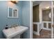 Bathroom with blue walls, pedestal sink, and tiled floor at 9037 J M Keynes Dr # 23, Charlotte, NC 28262