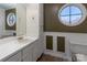 Bathroom featuring oval window, white cabinets, and neutral tones at 9037 J M Keynes Dr # 23, Charlotte, NC 28262