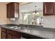 Practical kitchen with stainless steel dishwasher, dark cabinets, and view to the living area at 9037 J M Keynes Dr # 23, Charlotte, NC 28262