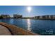 Lakeshore Village offers a peaceful lakefront view with modern buildings and sunny skies at 9037 J M Keynes Dr # 23, Charlotte, NC 28262