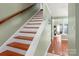Staircase with wood steps and white risers leading to a bright, inviting living area at 9037 J M Keynes Dr # 23, Charlotte, NC 28262
