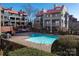 Community swimming pool with lounge area, surrounded by well-maintained buildings and greenery, offers a refreshing escape at 9037 J M Keynes Dr # 23, Charlotte, NC 28262