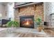Stone fireplace featuring a burning fire, hearth, and a decorative house plant on each side at 9428 Liberty Hill Dr, Mint Hill, NC 28227